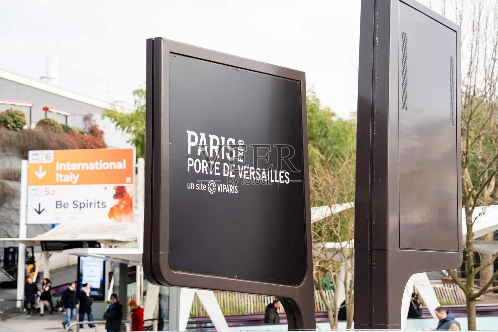 在晴朗的天空下，探索巴黎凡尔赛门展览中心在国际活动期间的活力四射的氛围照片摄影图片