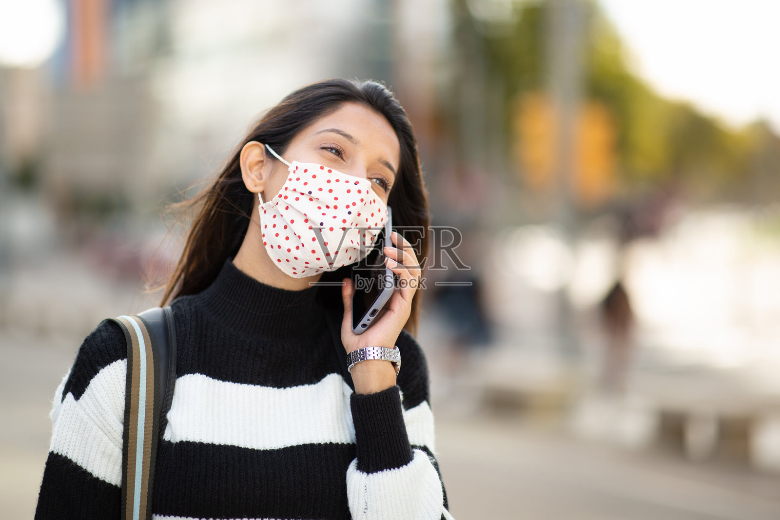 年轻女性戴着口罩用手机通话照片摄影图片