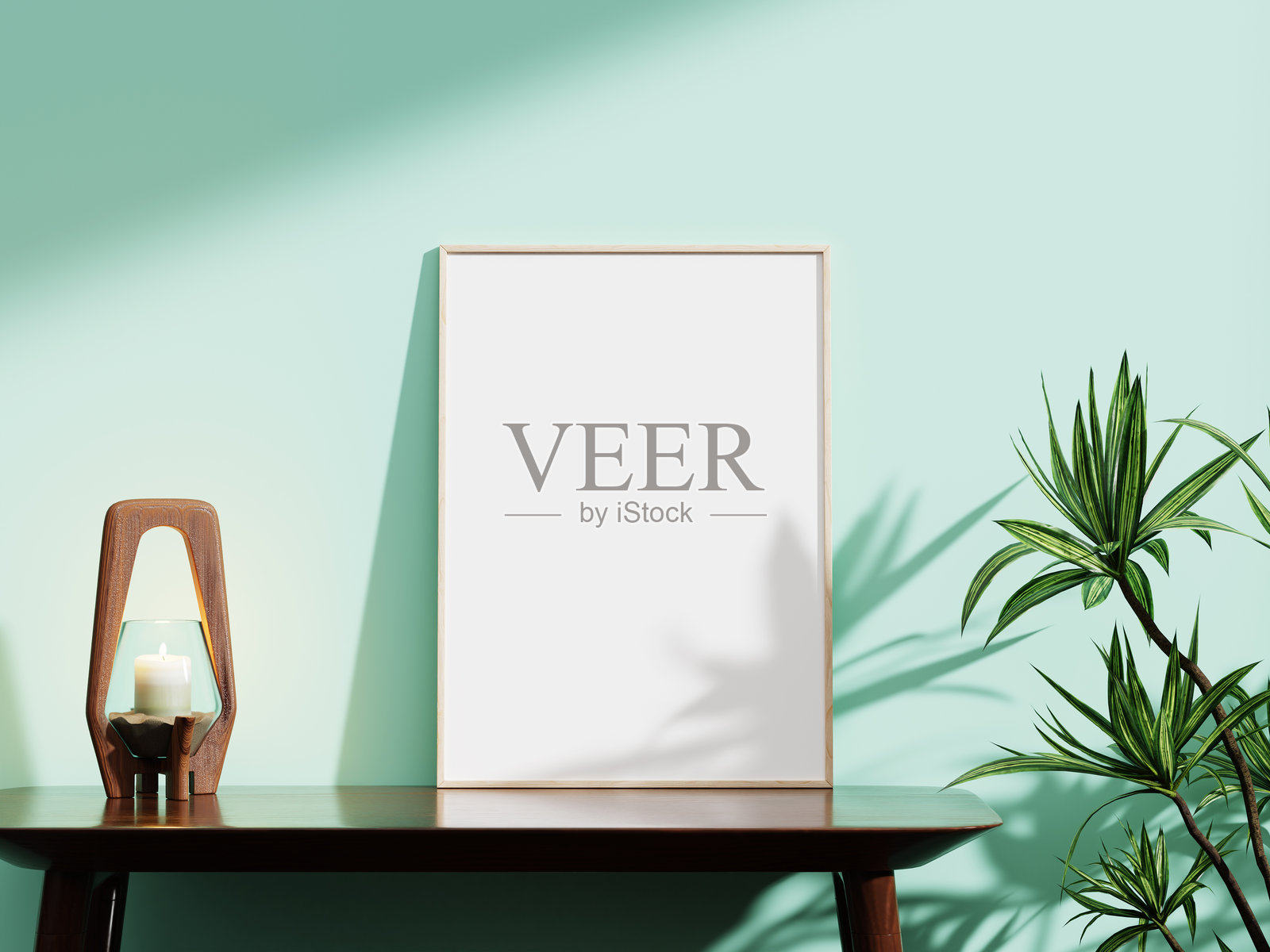 时尚的白色框架模型，背景是薄荷绿色的墙壁，配有木质蜡烛架和郁郁葱葱的植物，非常适合展示创意设计。照片摄影图片