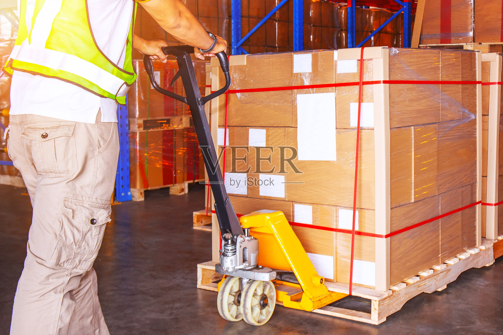 工人在仓库中装载包裹箱和托盘。叉车和托盘搬运车。分销存储仓库。供应链，运输物资仓库。物流。照片摄影图片