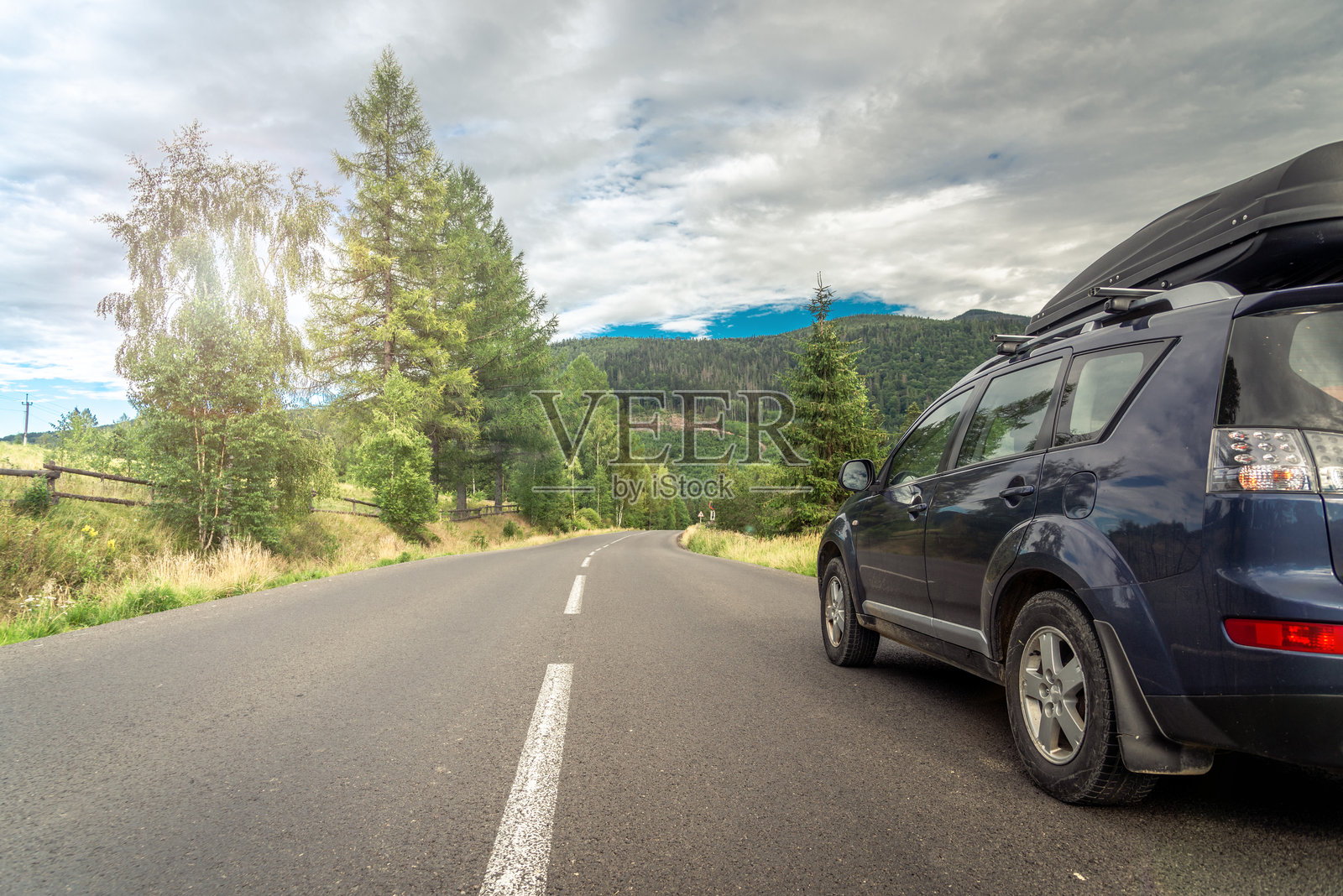 穿着白色浴袍的女人躺在沙发上，享受着橙色鸡尾酒，悠闲地在屋顶上放松。照片摄影图片