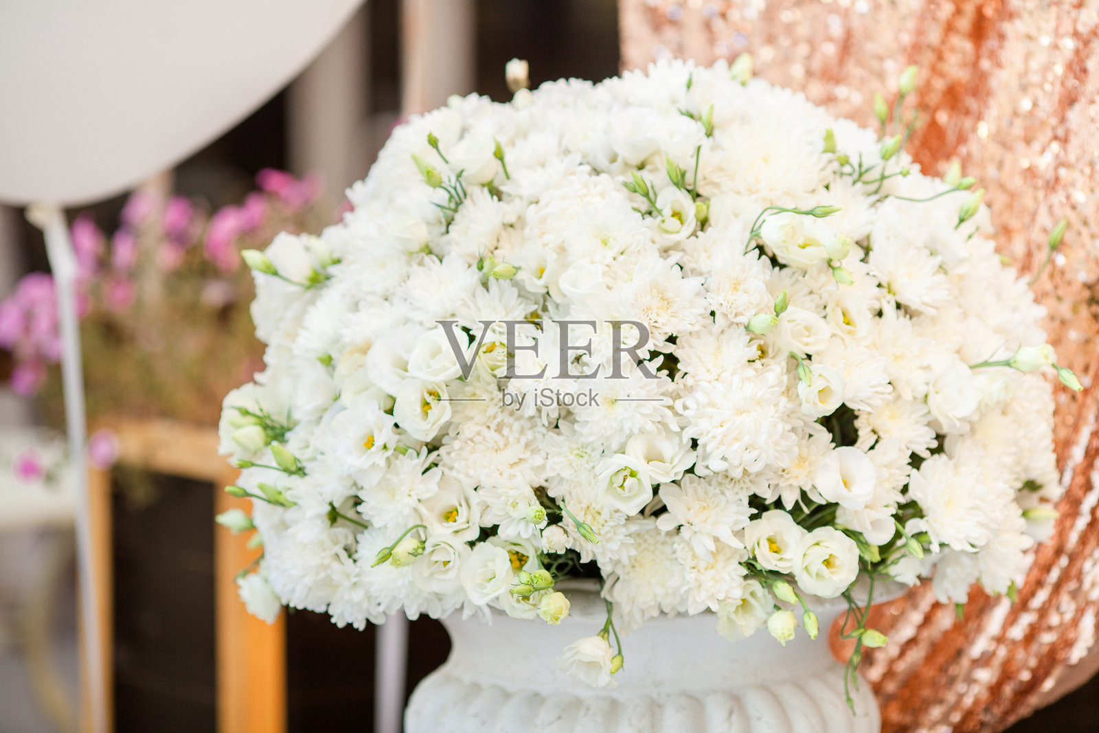 婚礼装饰。餐厅内金色背景上的白色花束照片摄影图片