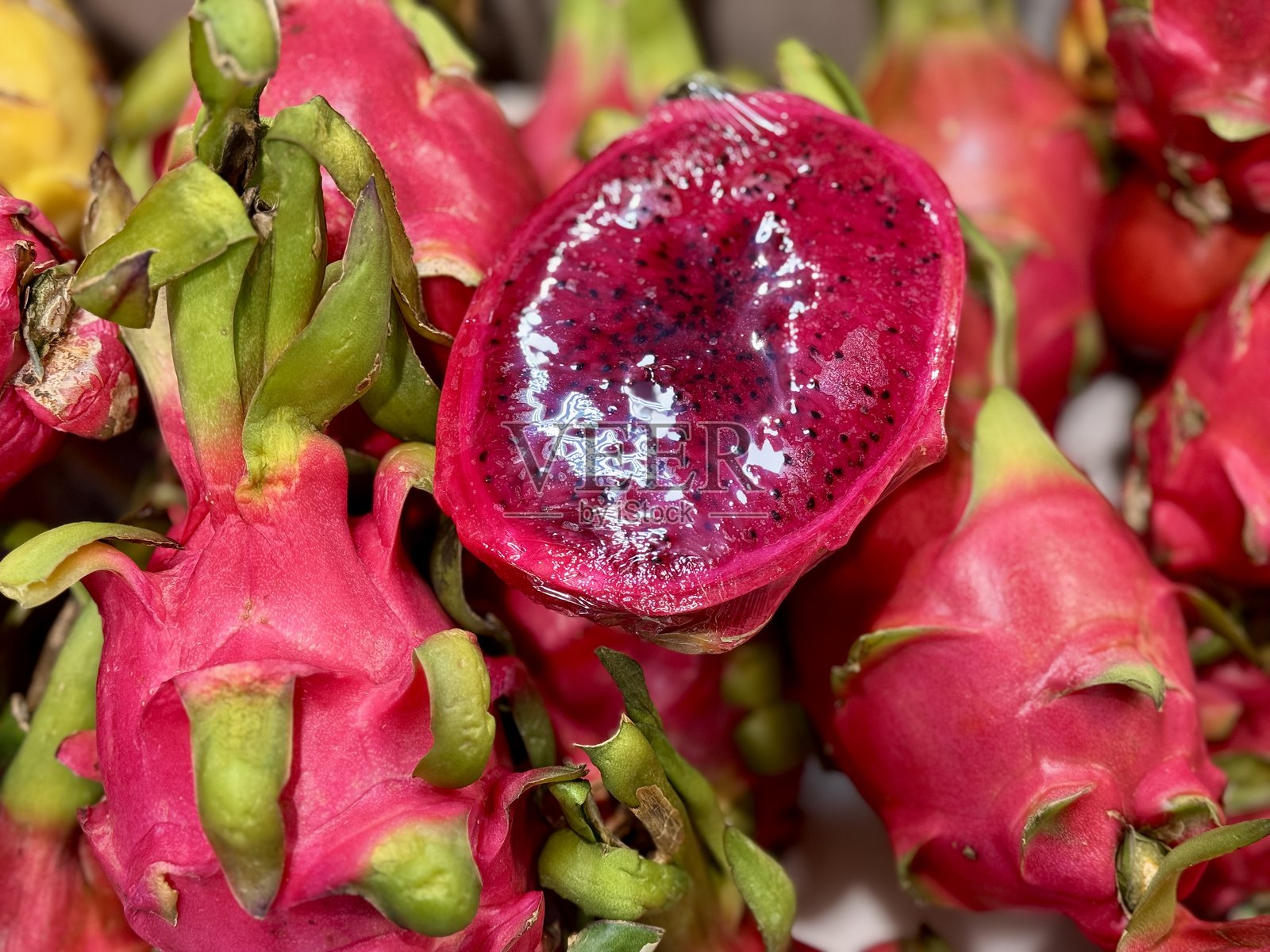 在农贸市场上，华丽切割的火龙果（来自于夜仙人掌或檀香山女王）被堆放在展示架上。特写镜头。照片摄影图片