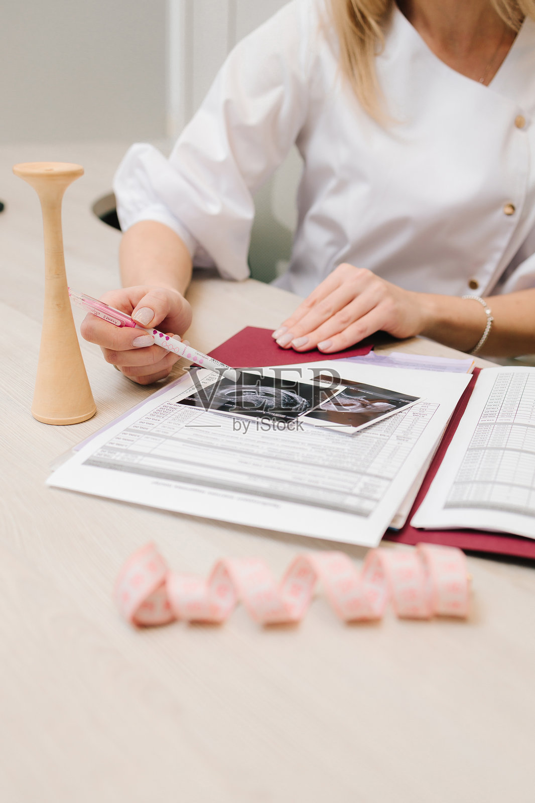 妇科医生在医疗中心的预约中向孕妇展示胚胎。妇科医生检查超声波胚胎扫描的结果。照片摄影图片