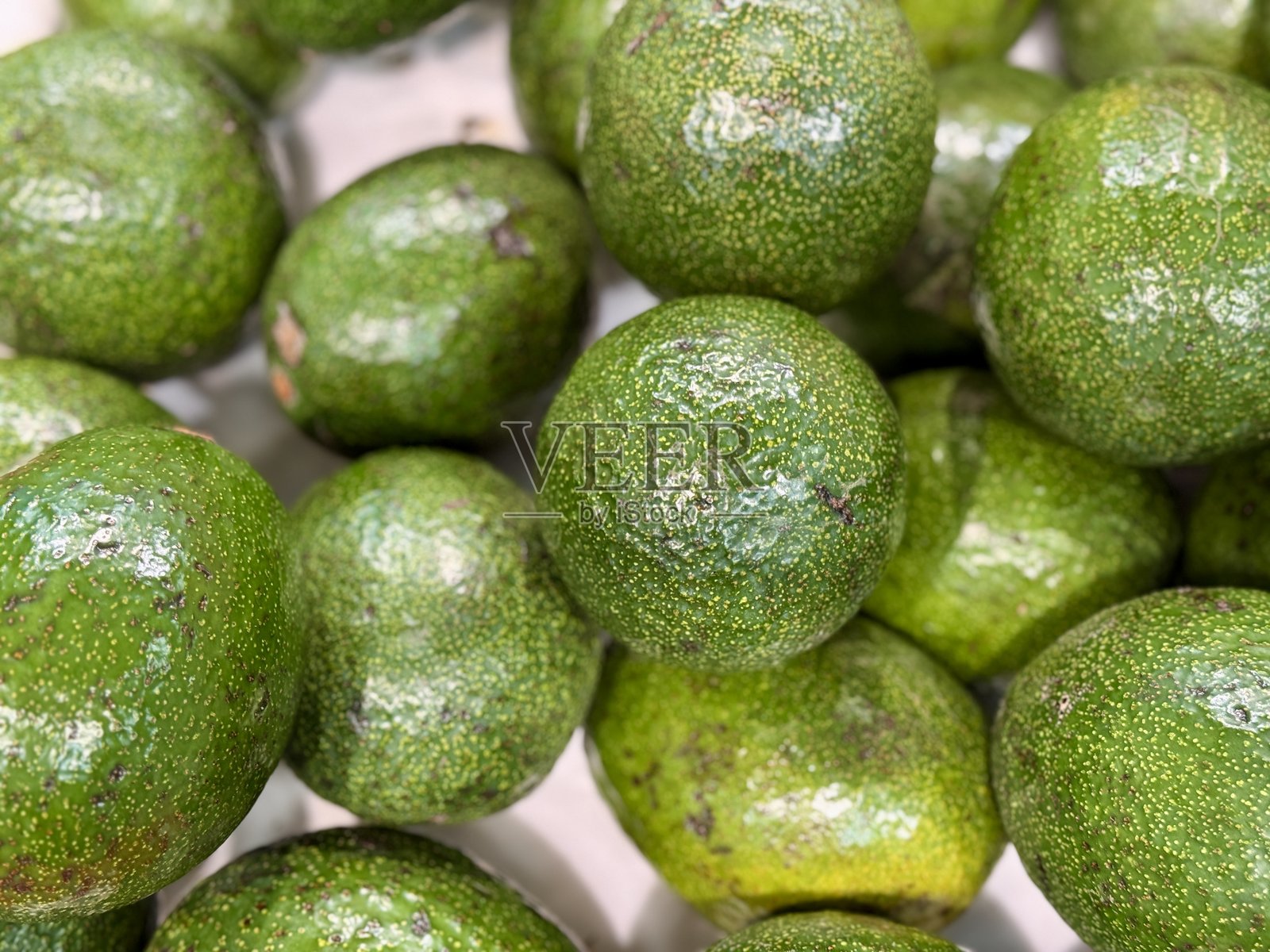 从上方俯视，超市货架上摆放着已采摘的绿色大鳄梨，准备食用。健康饮食。特写。照片摄影图片