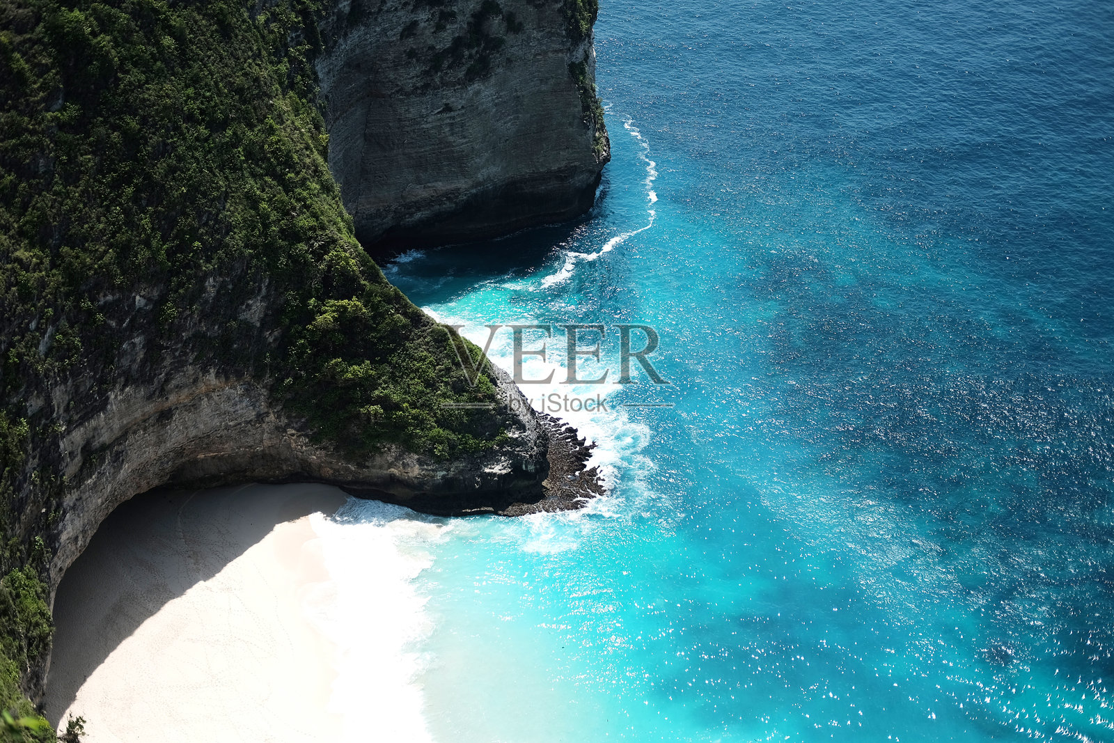 美丽的海洋悬崖洞穴空中景观，海浪拍打着岩石，巴厘岛Kelingking海滩的水花四溅。照片摄影图片