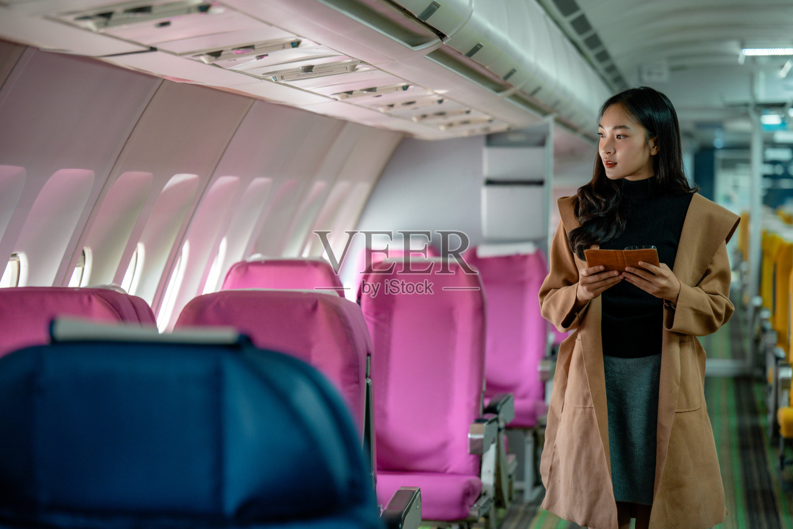 女空乘人员在飞机客舱内进行安全检查，专业地协助乘客。照片摄影图片