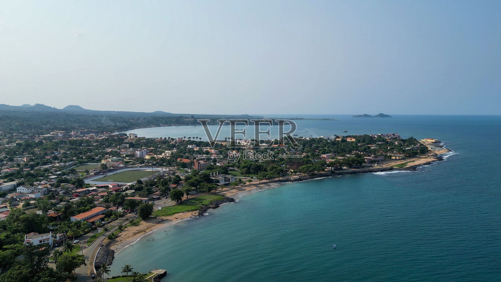 海滨小镇的鸟瞰图，绿意盎然，海洋宁静。照片摄影图片