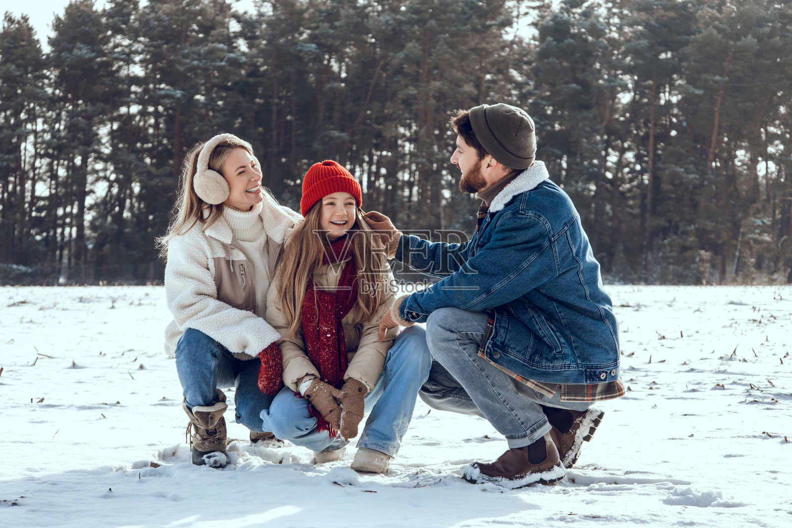 快乐的家庭在森林中享受雪天，一起玩得很开心照片摄影图片