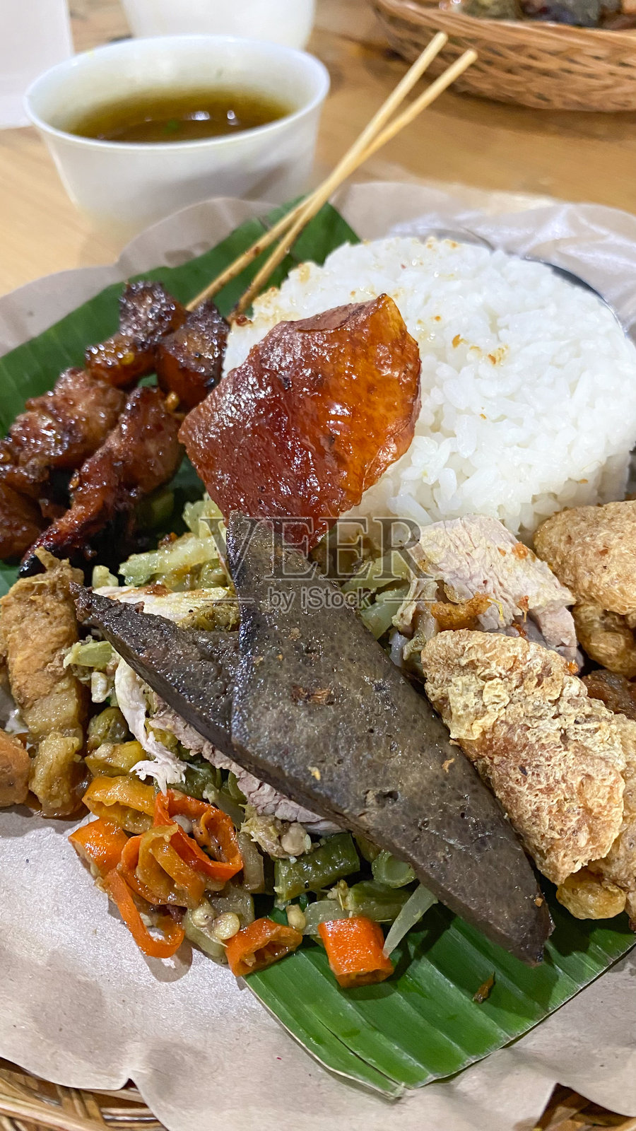 巴厘岛烤乳猪或巴厘岛风味的烤猪肉，配有香辣酱，盛放在木盘上。正宗的巴厘岛美食，使用了丰富的香料和多样的菜单。照片摄影图片