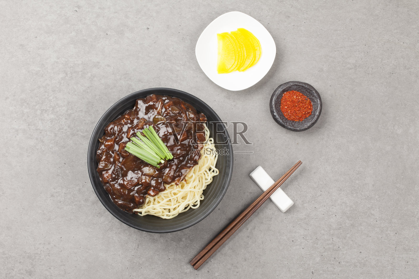 炸酱面是中国菜之一。面条与炒肉和蔬菜的中国豆瓣酱混合在一起。照片摄影图片