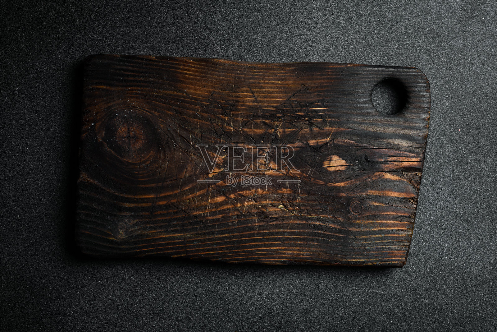 厨房棕色木质切菜板。背景为深色石板。食谱的空白空间。照片摄影图片