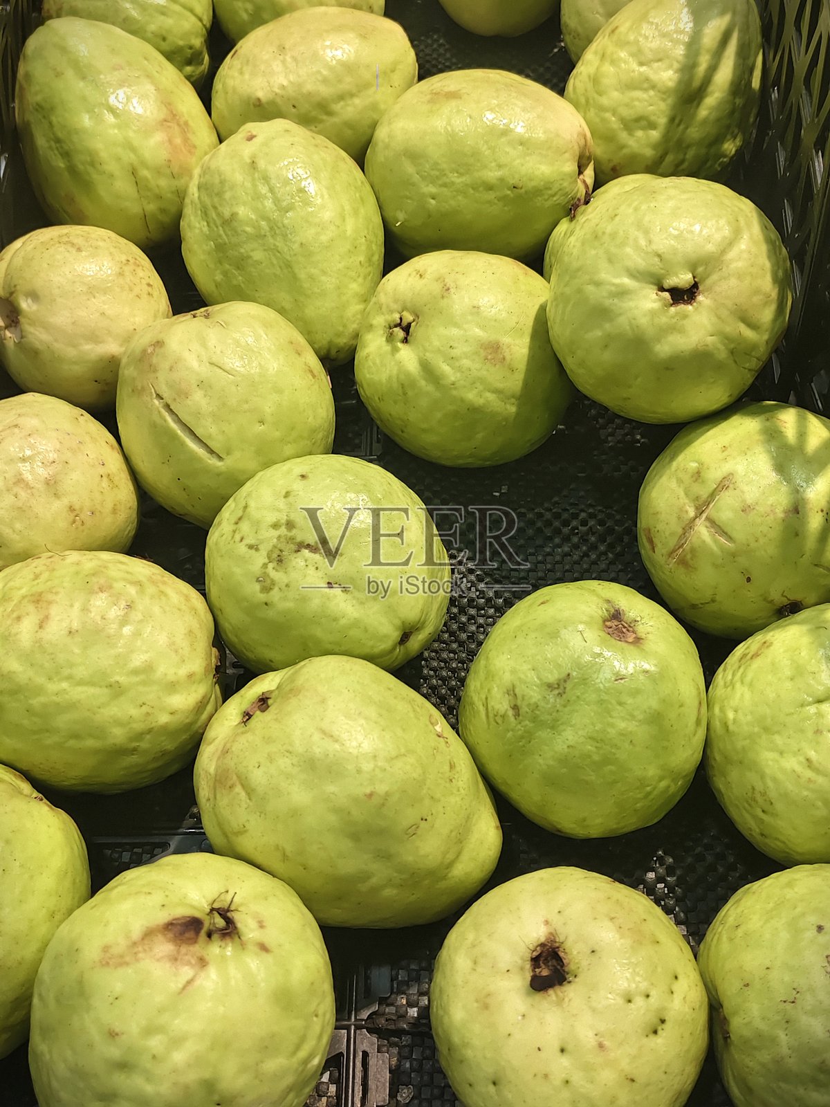 市场摊位上展示的新鲜绿色番石榴出售照片摄影图片