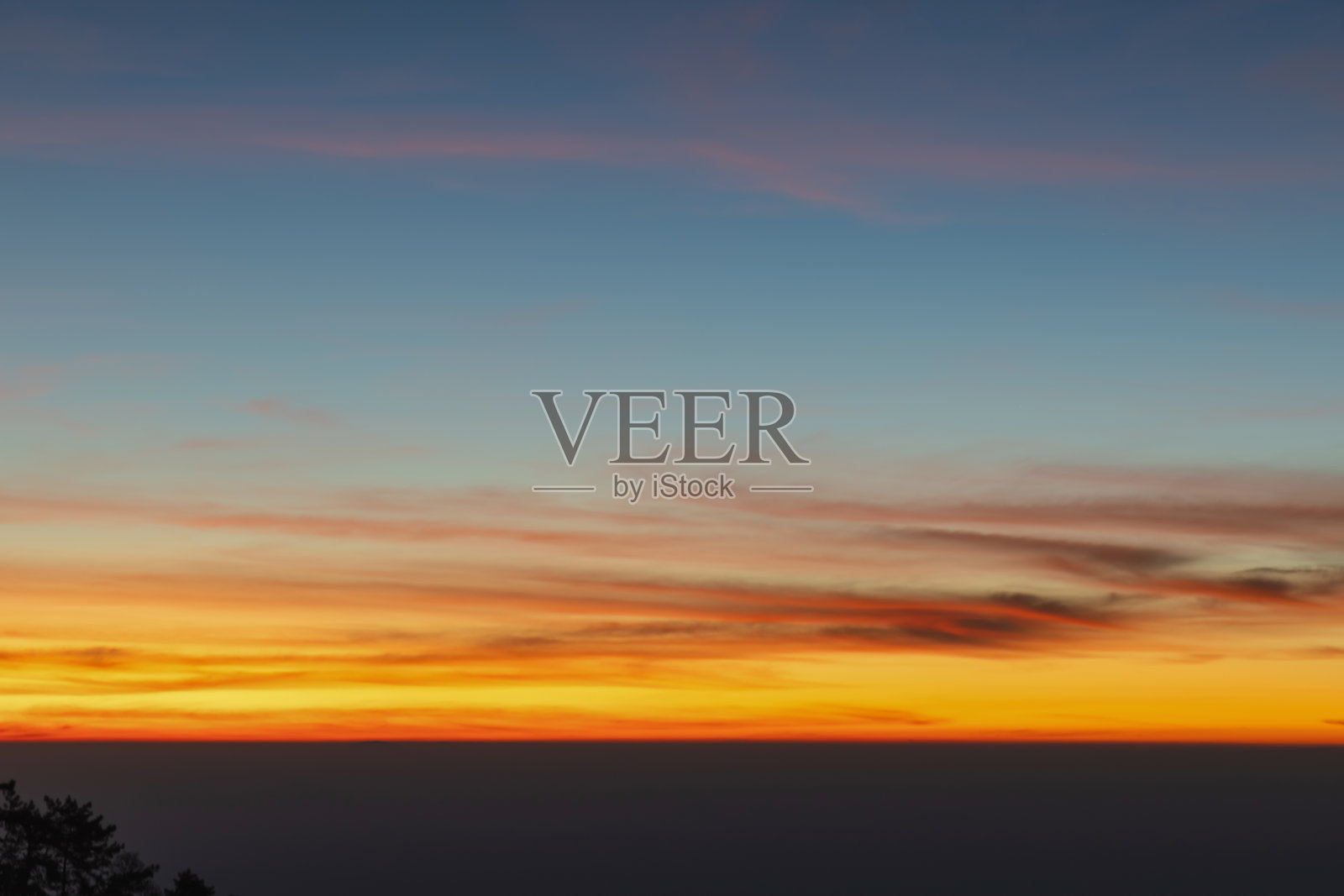 清晨的天空，留有空白空间。平滑的橙蓝渐变的黎明天空。日落、日出背景。自然色彩。橙色和红色的戏剧性色彩。照片摄影图片