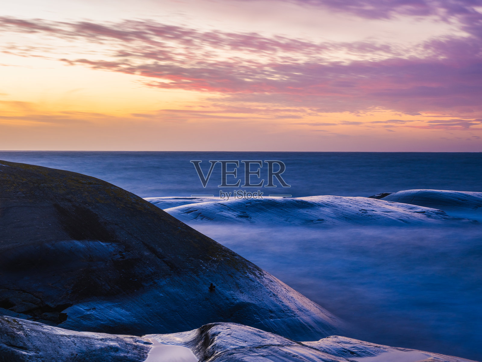 瑞典日落时的海岸风光，展现宁静的水面和岩石 formations照片摄影图片