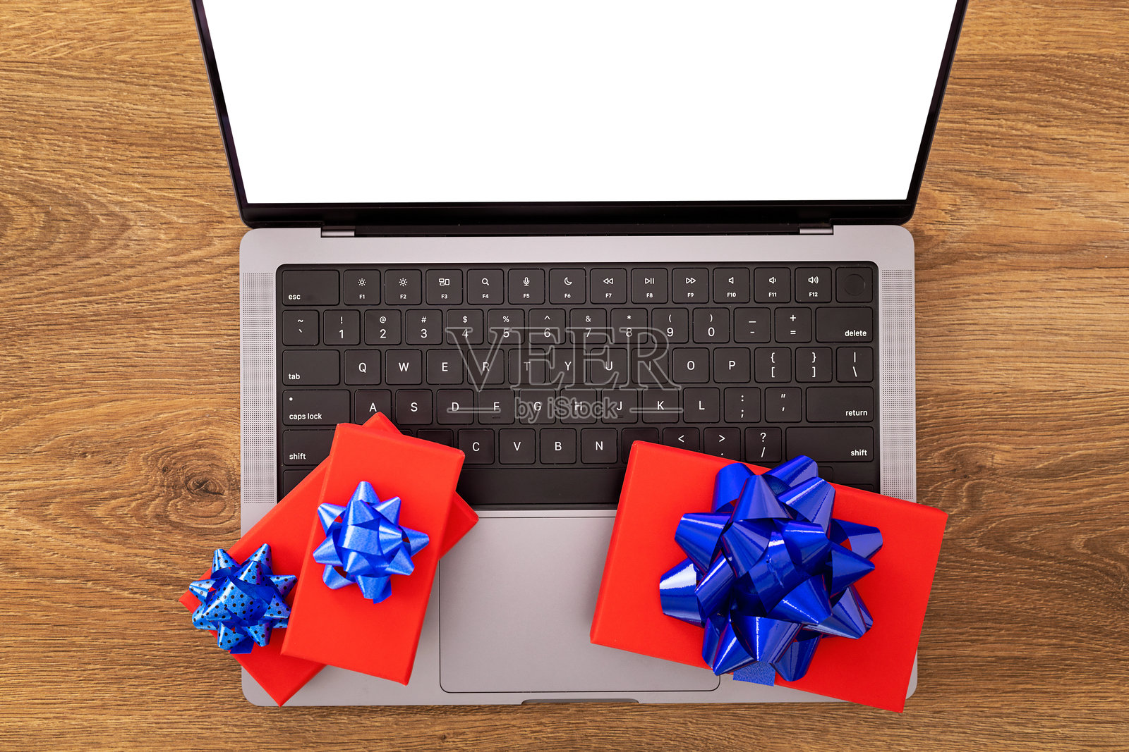 木质背景上的笔记本电脑与礼品盒照片摄影图片