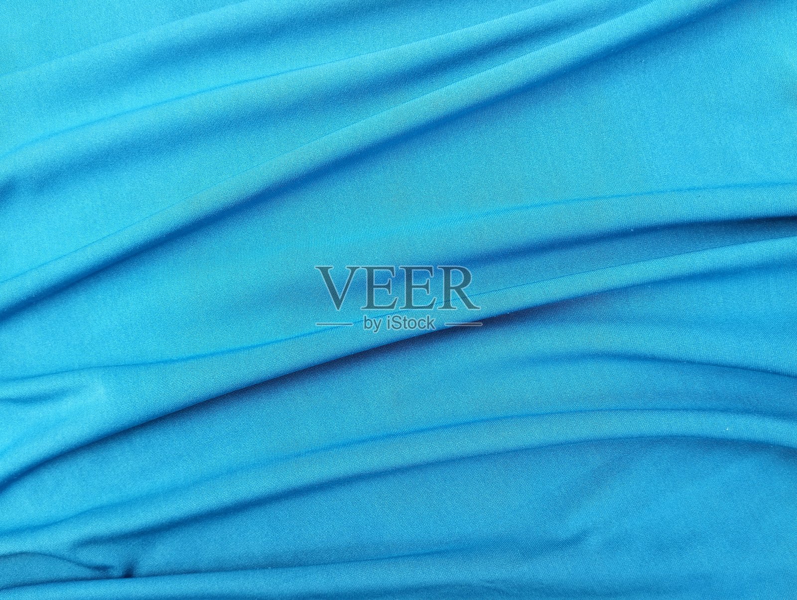 浅蓝色抽象背景。丝绸缎面质感背景。照片摄影图片