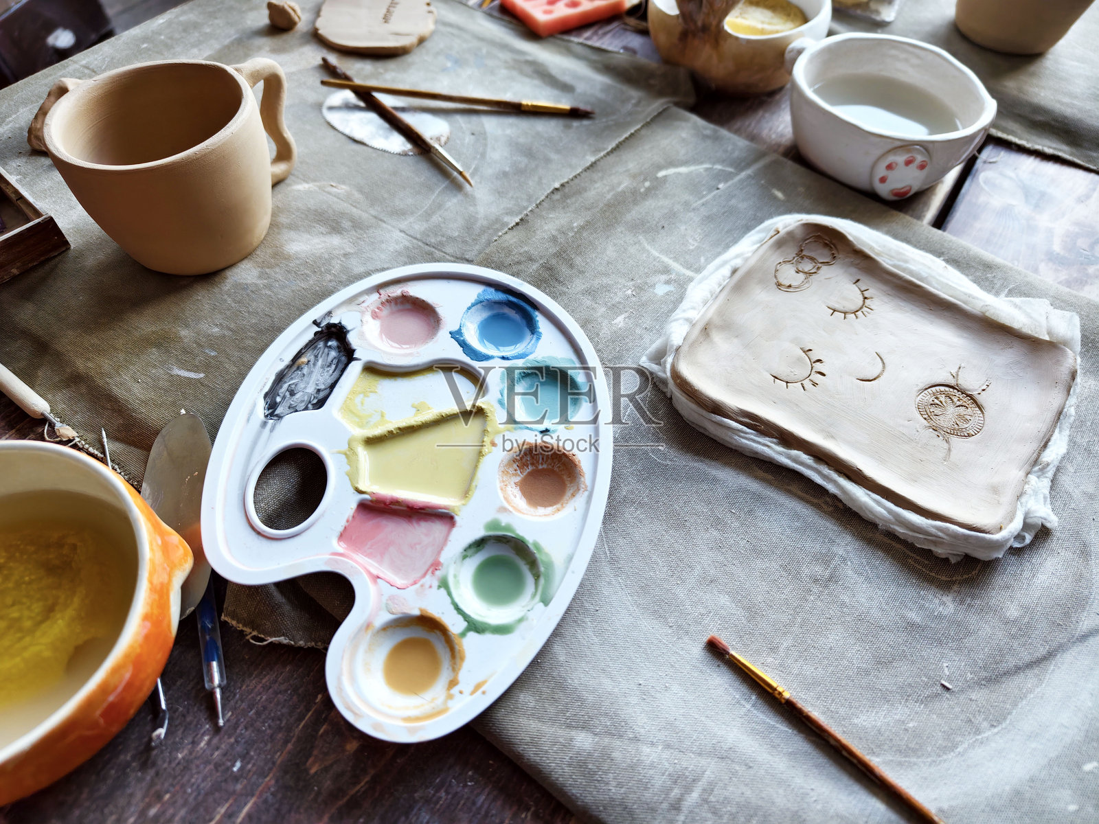 儿童陶艺工作坊。孩子们学习如何使用粘土制作餐具。照片摄影图片