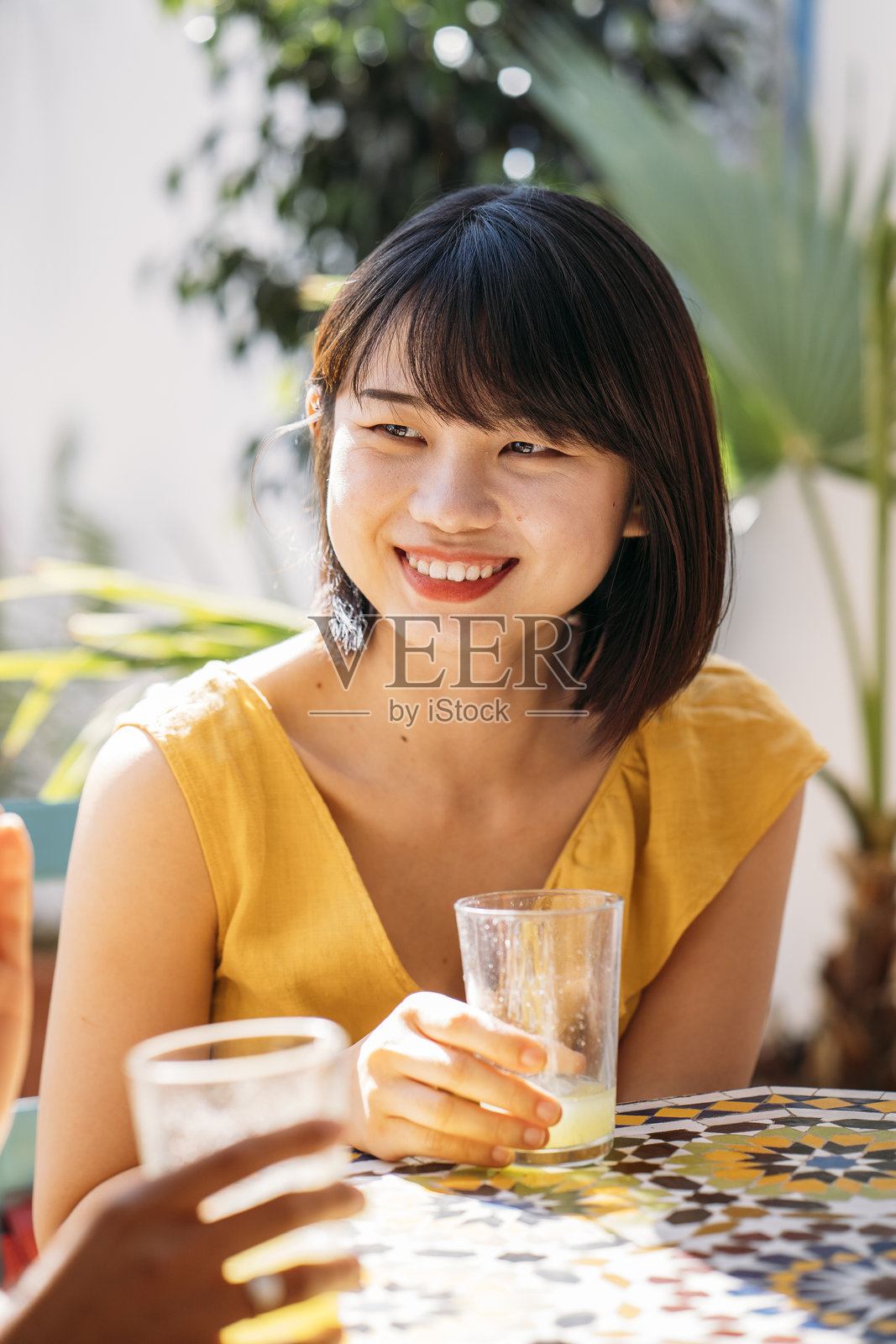 大学交换生在阳光明媚的庭院中享用清爽饮品照片摄影图片