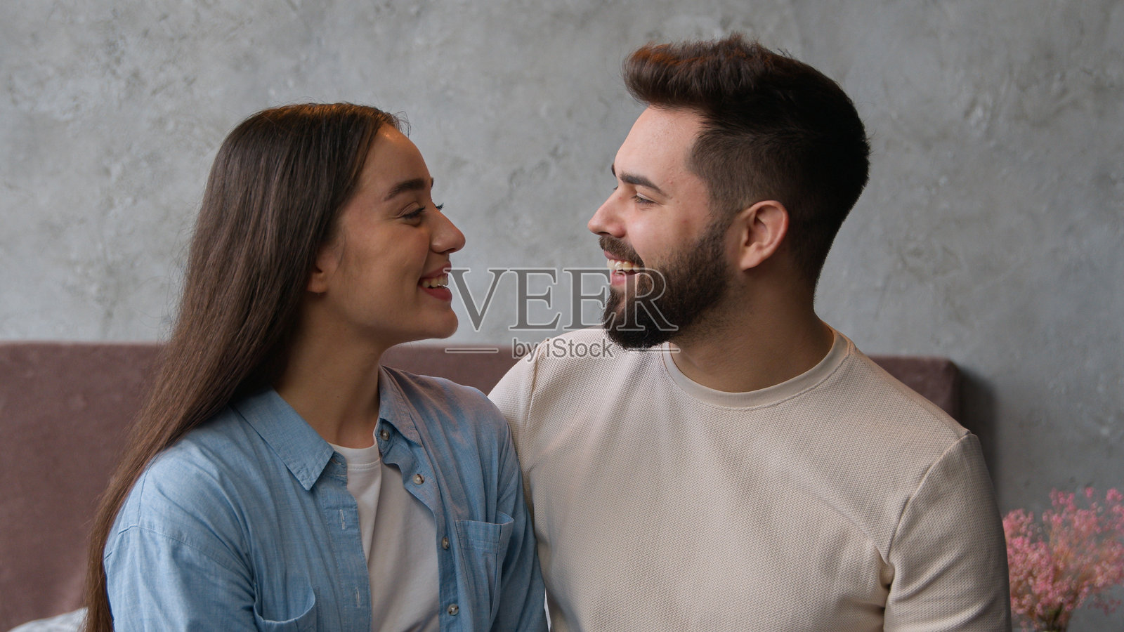 白人已婚幸福家庭在卧室里，微笑的情侣互相凝视，展现出亲密的爱情关系，妻子依偎在心爱的丈夫身旁。照片摄影图片