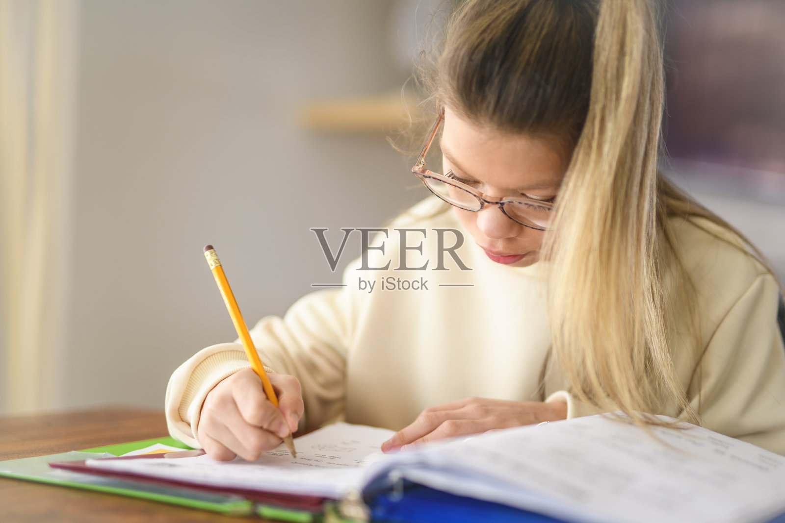 家庭作业和学校概念 - 微笑的青少年女孩在家里用书写笔记本照片摄影图片