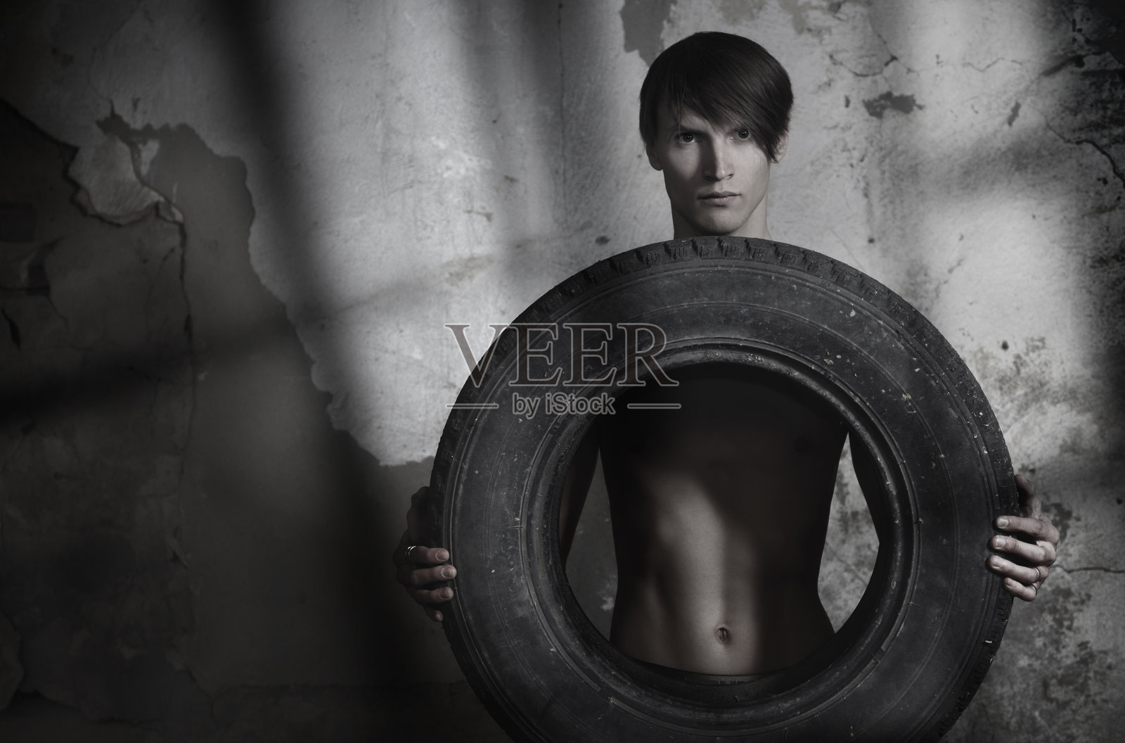 拿着轮胎的男人照片摄影图片