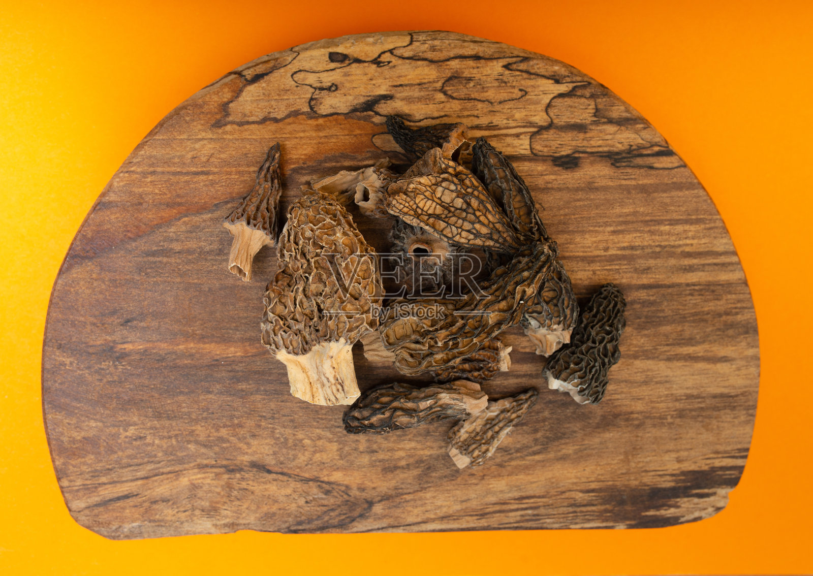干燥的羊肚菌放在木质厨房砧板上。俯视构图。照片摄影图片