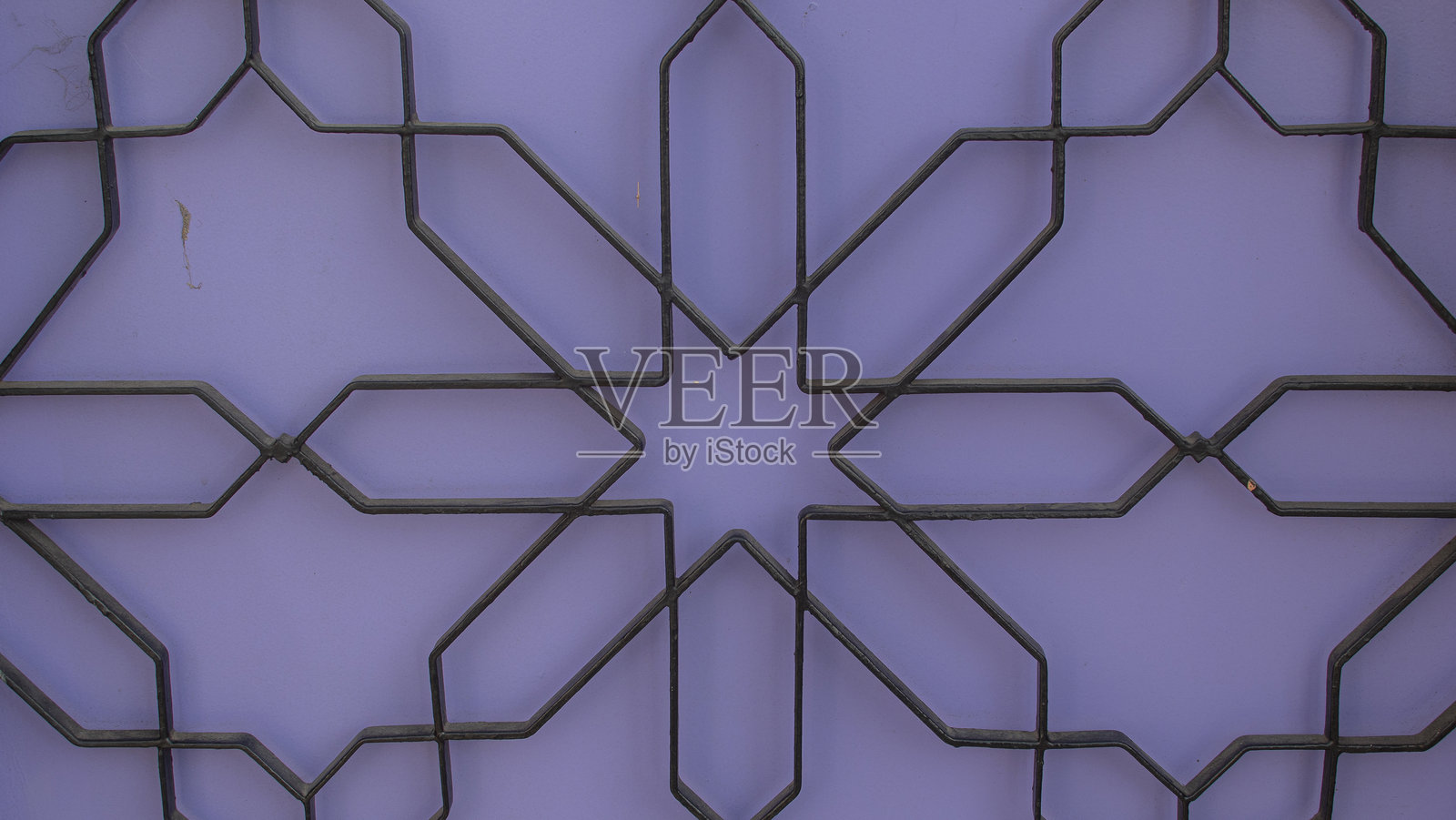 紫色墙壁前的星形黑铁栅栏照片摄影图片