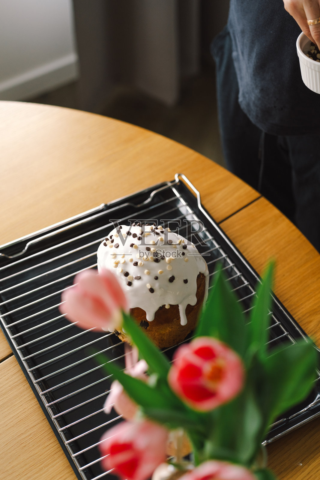 在春季准备期间，在厨房台面上烘焙节日复活节潘娜托尼蛋糕，并在上面涂抹糖霜照片摄影图片