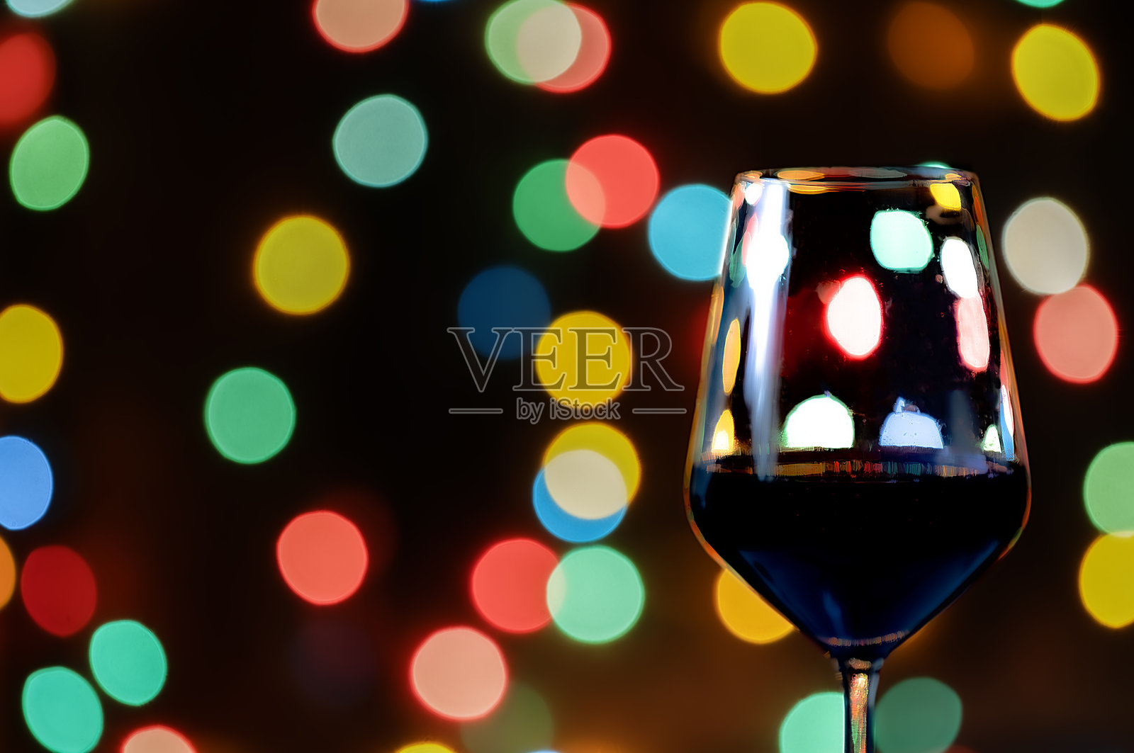 酒杯浸泡在圣诞灯光的花束中照片摄影图片