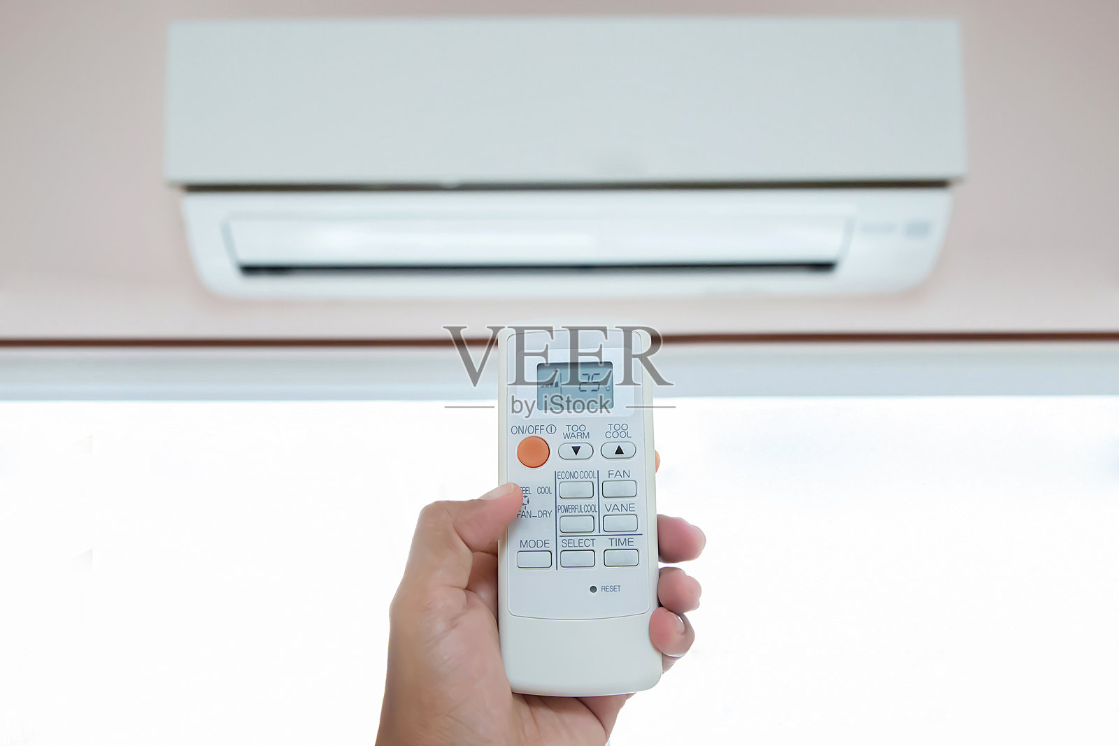 手部特写与空调遥控器。照片摄影图片