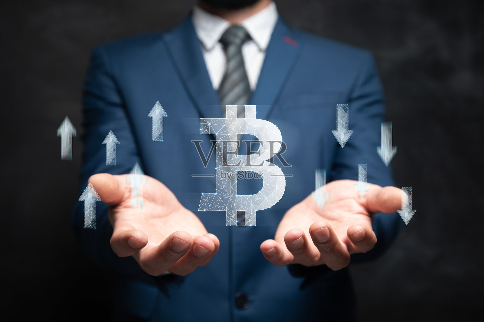 比特币图标和上下箭头从网络中延伸。男人手中握着。照片摄影图片