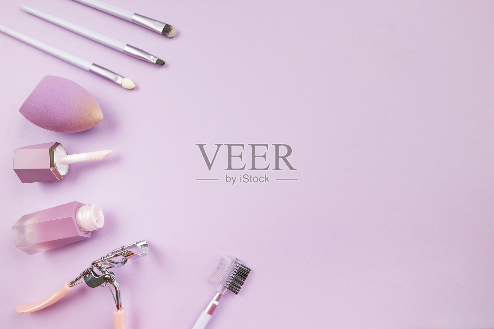 化妆概念。俯视照片。专业装饰性化妆品、化妆工具和配件在淡紫色背景上，留有空白空间。照片摄影图片