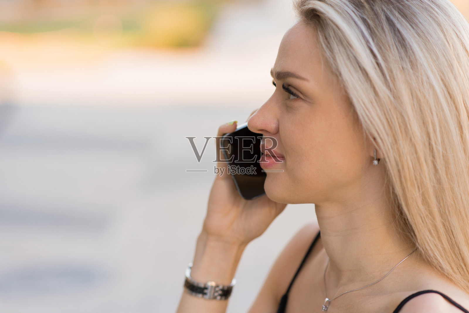 快乐的年轻白人女性在城市中用手机交谈照片摄影图片