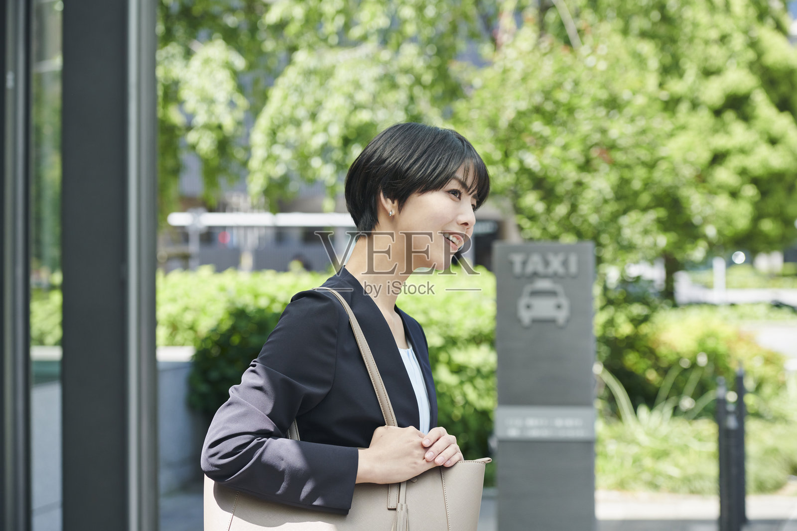 一位30多岁的女性办公室职员在等出租车照片摄影图片