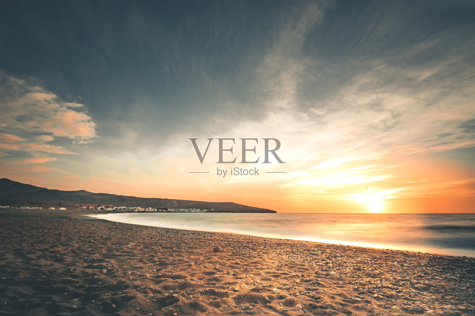 海洋和沙滩上的日出，岩石，天空中的绚丽色彩，长时间曝光拍摄。记录于加那利群岛的富埃特文图拉岛。照片摄影图片