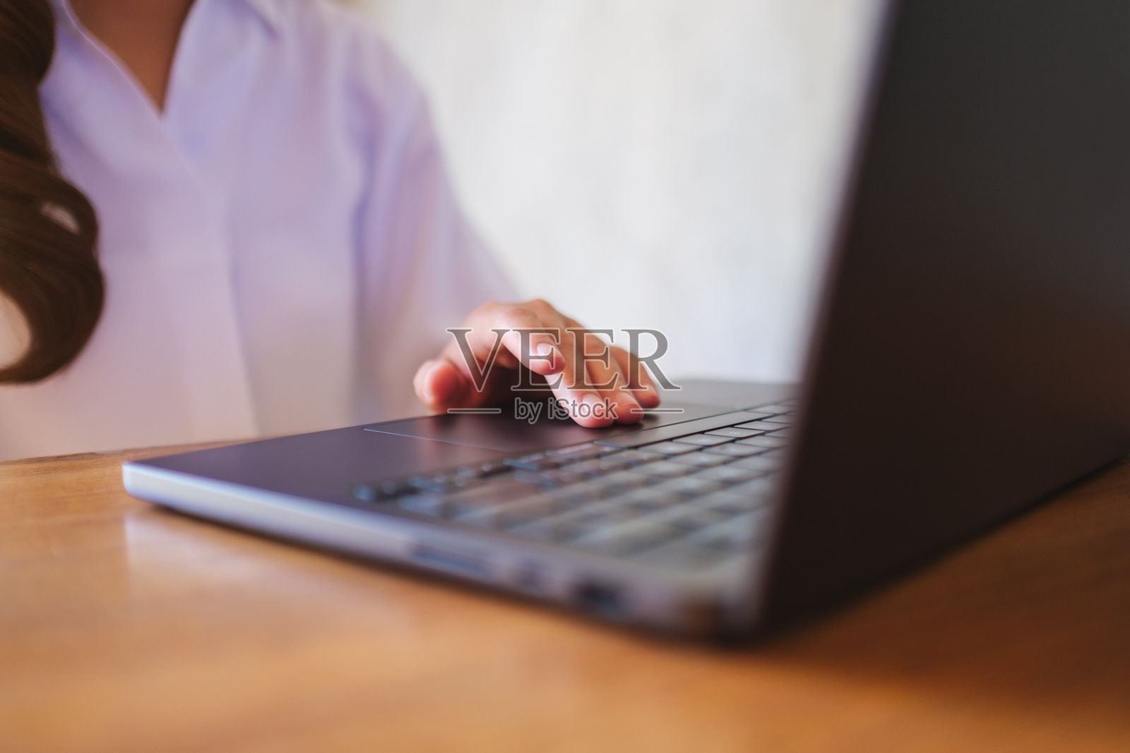 特写镜头，女性在使用笔记本电脑触控板工作。照片摄影图片