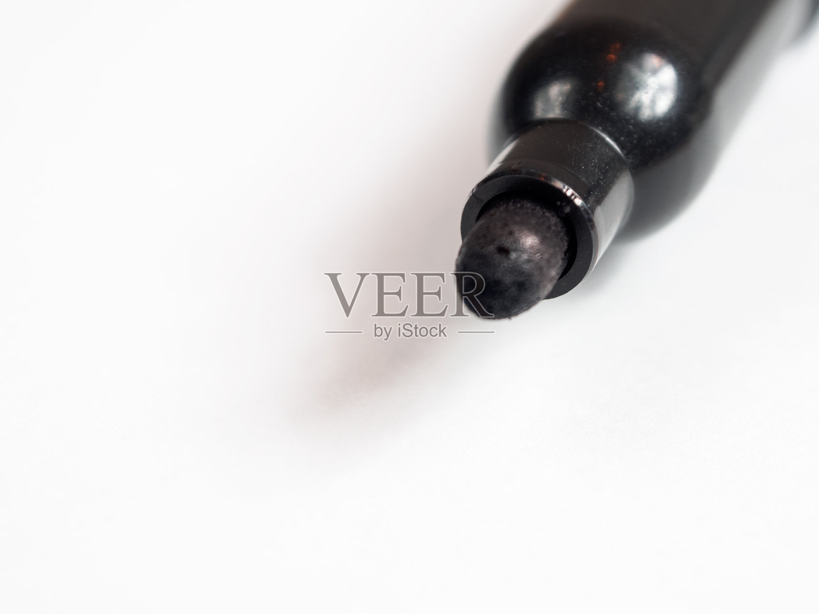 一支标记笔放置在空白纸张上，背景有充足的空白空间。照片摄影图片