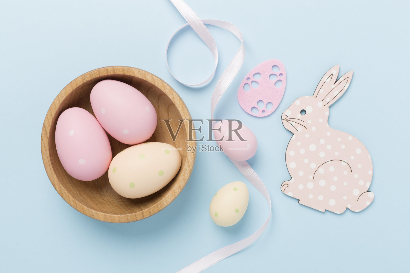 复活节兔子与彩色背景上的鸡蛋，俯视图照片摄影图片