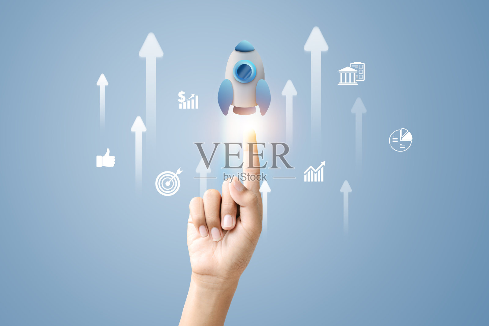 一只手指向一枚发光的火箭，周围有向上的箭头和商业图标照片摄影图片
