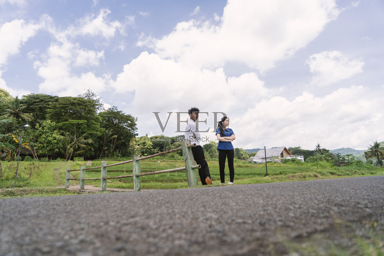 活力四射的亚洲年轻情侣在乡村地区锻炼间歇时互相聊天。照片摄影图片