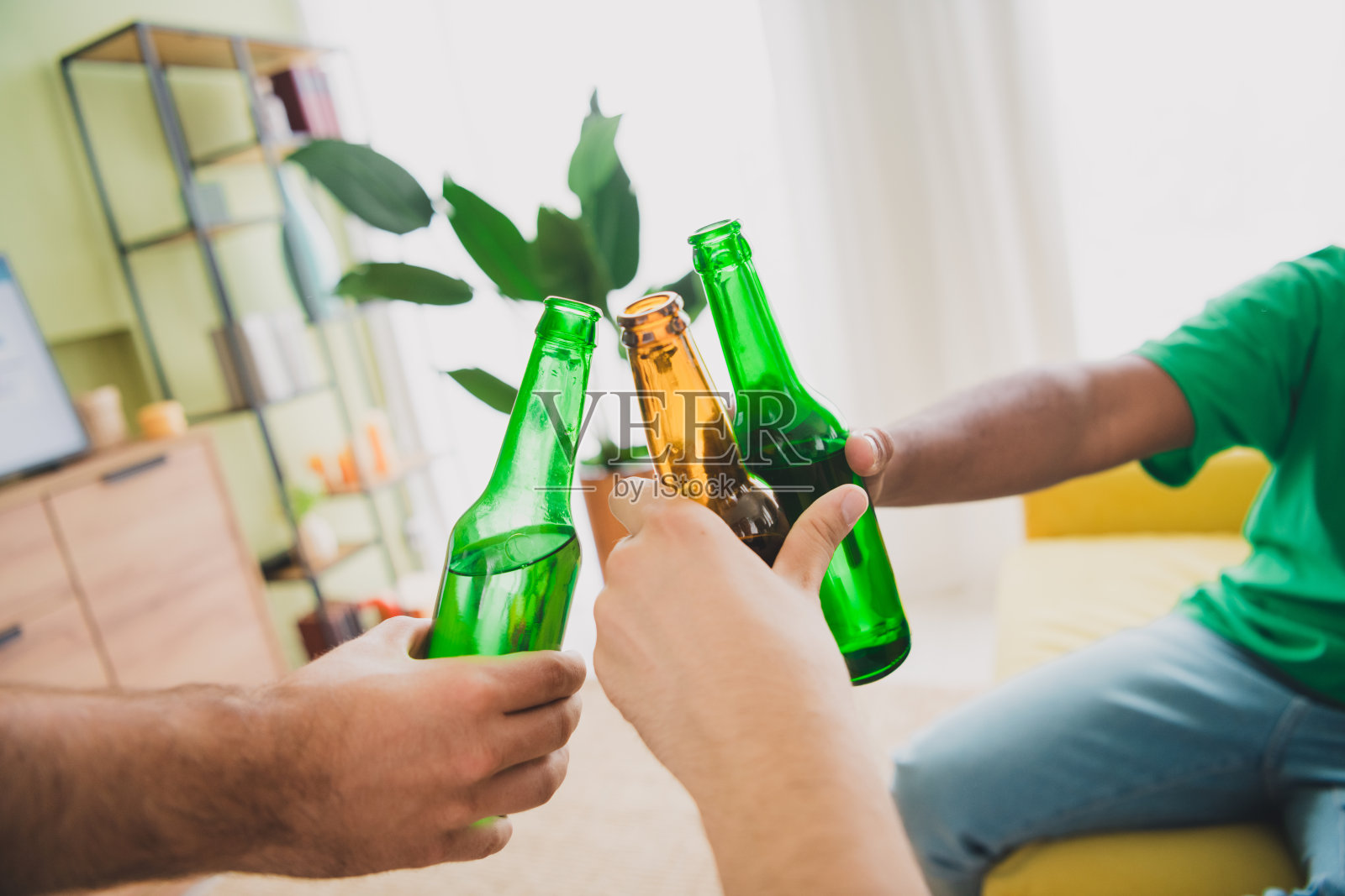 一群年轻朋友在现代绿色室内公寓里碰杯，剪裁的肖像。照片摄影图片