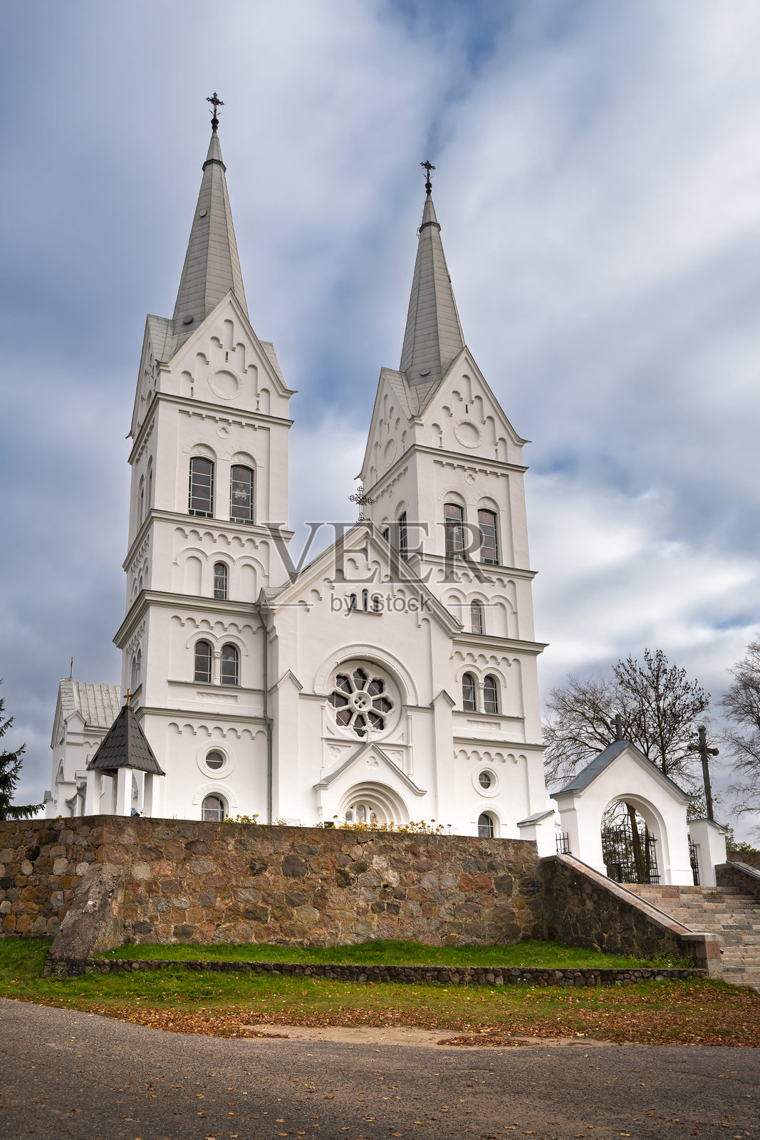 白色的新哥特式天主教教堂，位于白俄罗斯布拉斯拉夫湖的斯洛博德卡，拥有两座高耸的尖塔、拱形窗户和精致的细节。照片摄影图片