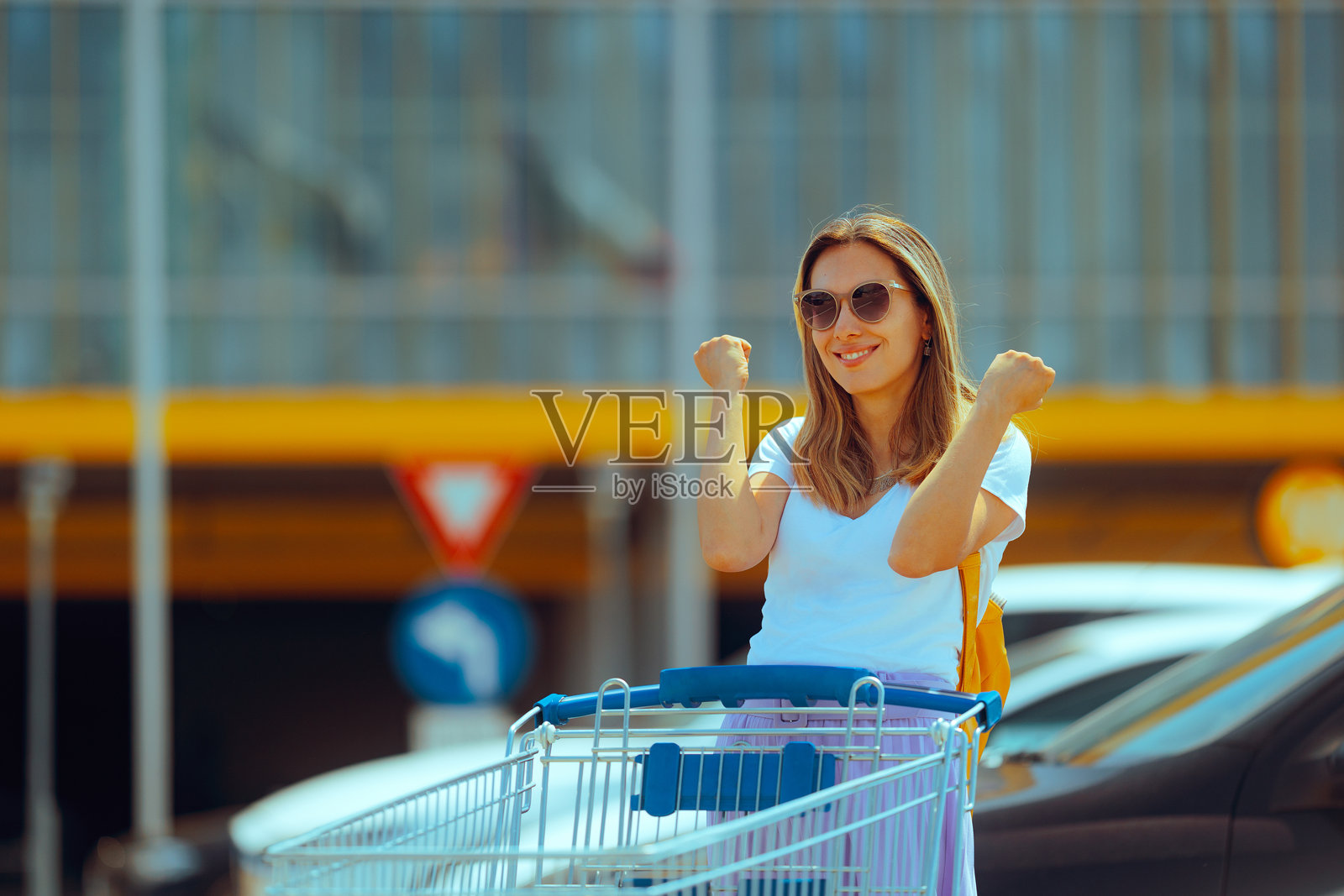 快乐的女性在外推着超市购物车照片摄影图片