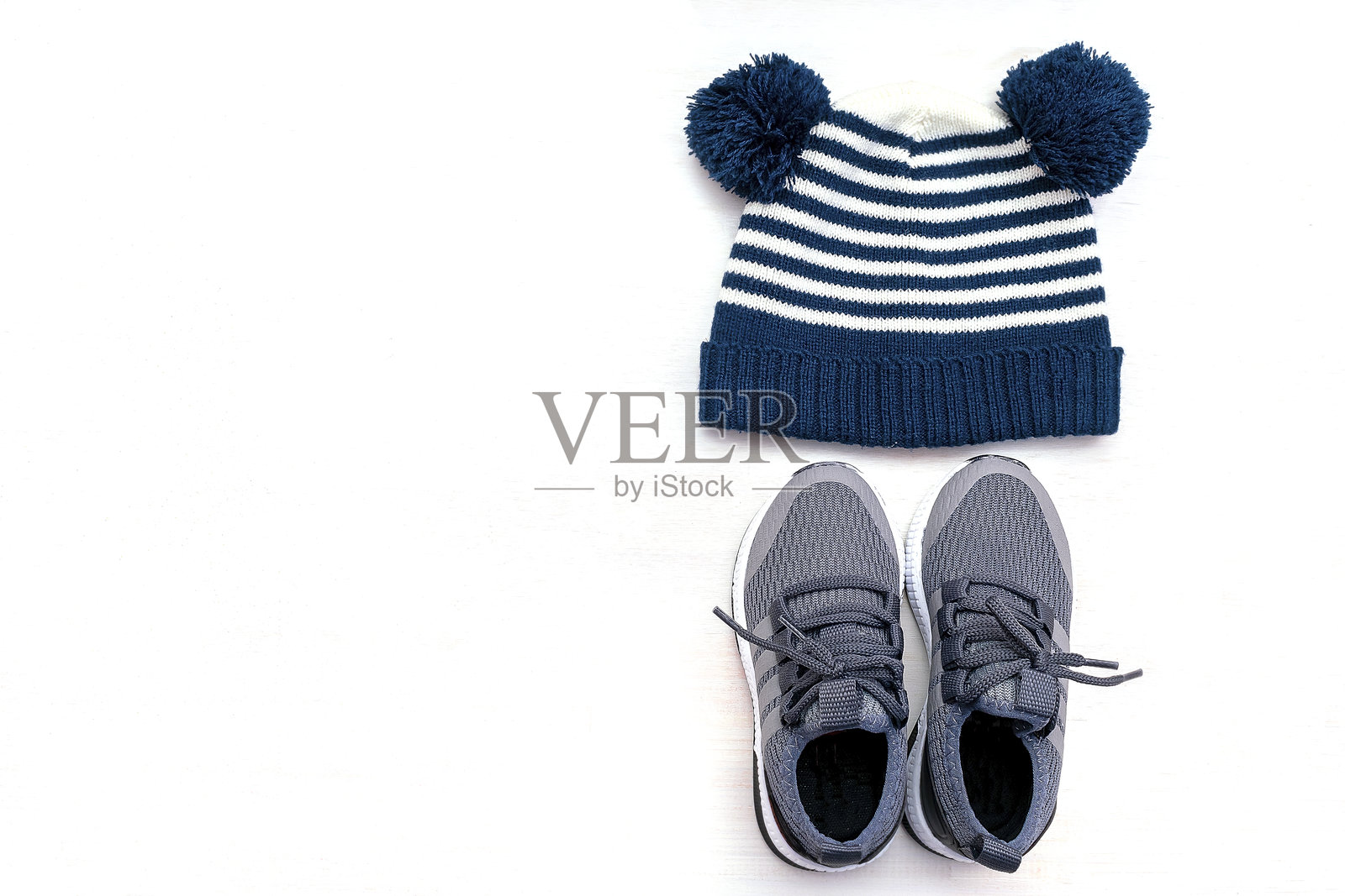 婴儿帽子、针织帽、运动鞋。春秋季儿童服装，白色背景。时尚儿童服装搭配。照片摄影图片