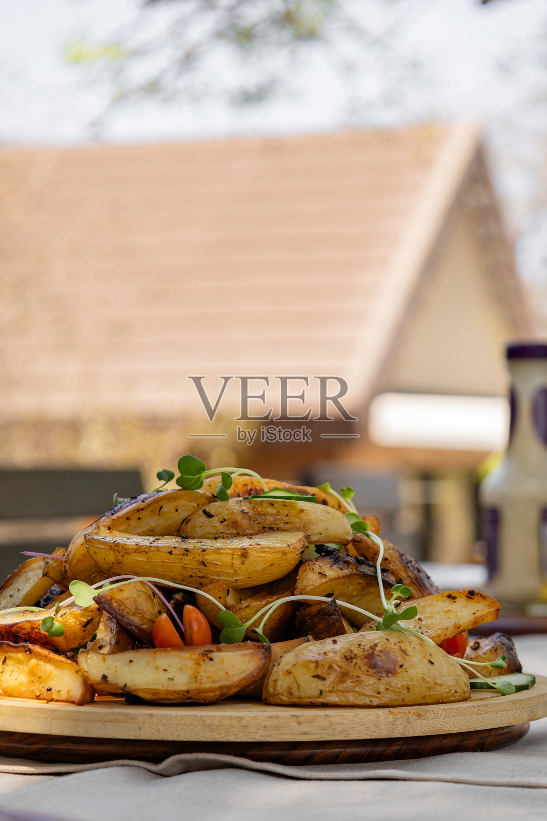 脆皮烤土豆角，配以微型绿叶，摆放在木盘上照片摄影图片