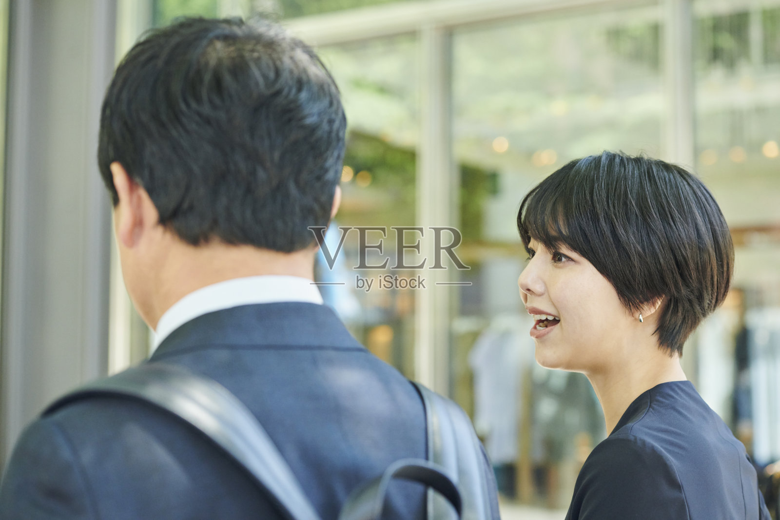 一位五十多岁的男性办公室工作人员和一位三十多岁的女性办公室工作人员在商业区散步照片摄影图片