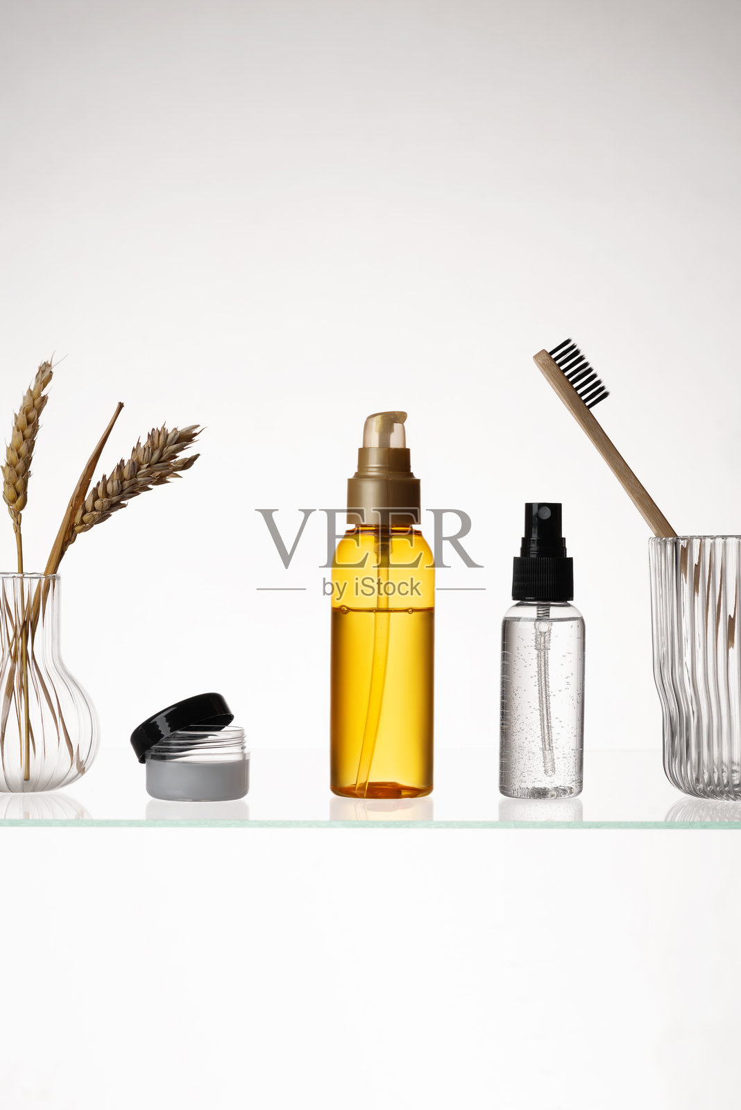 白色背景下玻璃架上的不同化妆品。玻璃架上的护肤和沐浴产品展示图。照片摄影图片