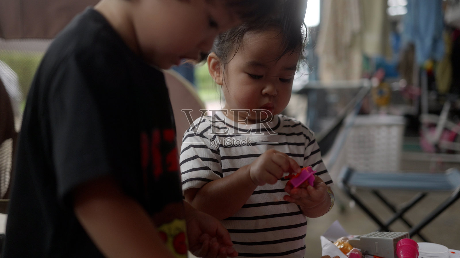 快乐的亚洲男孩和妹妹一起玩史莱姆。照片摄影图片