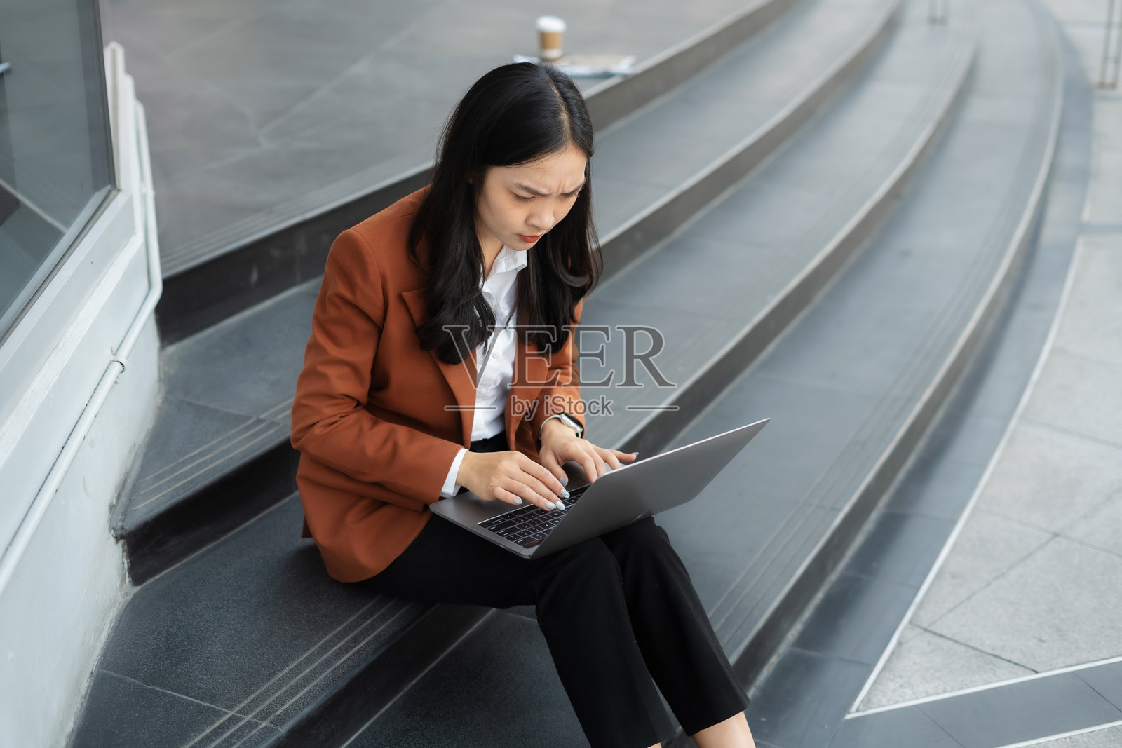 感到压力的女商人正在笔记本电脑上应对财务危机，处理客户不满、企业失败和职场挑战。照片摄影图片